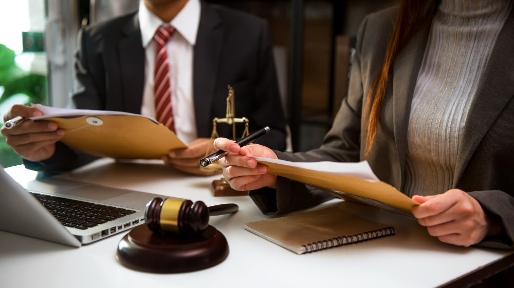 business-lawyers-discussing-contract-papers-with-brass-scale-desk-office-law-legal-services-advice-justice-law-concept-3.jpg